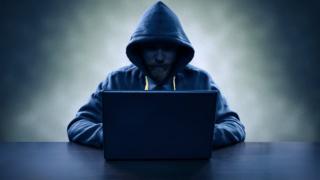 hooded man with lap-top