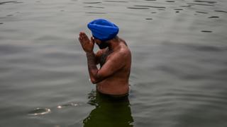 A Sikh devotee takes a holy dip on the occasion of the 550th birth anniversary of Sikhism founder Guru Nanak Dev at Gurudwara Bangla Sahib in New Delhi on November 12, 2019