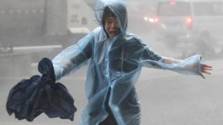 Una mujer corre bajo la lluvia en China