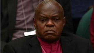 Dakta Santamu ya tsere Uganda a 1974 kuma ya zama babban limamin coci a 2005