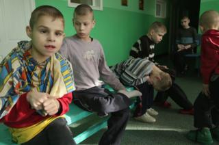 Young boys sit on a bench in their wing at the Vesnova Home for Invalid Children