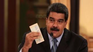 Venezuela"s President Nicolas Maduro holds a bank note from the new Venezuelan currency Bolivar Soberano (Sovereign Bolivar), as he speaks during a meeting with ministers at Miraflores Palace in Caracas, Venezuela August 17, 2018.