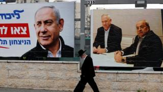 Man walks past election campaign posters in Jerusalem (file photo)