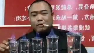 Liu Shichao fumando ao lado de copos com bebida