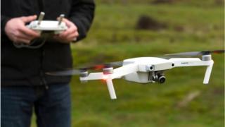 A drone pilot flying a DJI Mavic Pro in Wales