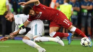 Mohamed Salah pugna con Ramos en la jugada en que se lesionó.