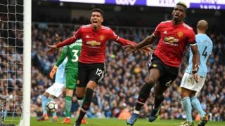 Paul Pogba (midig) iyo Chris Smalling ayaa dhaliyay goolasha ay Manchester United kaga badisay Man City