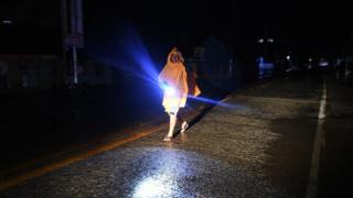 A resident walks along a deserted street and shopping mall as Typhoon Mangkhut approaches the city of Tuguegarao, Cagayan province, north of Manila on September 14, 2018