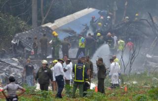 A picture taken at the scene of the accident shows charred portions of the plane and emergency workers