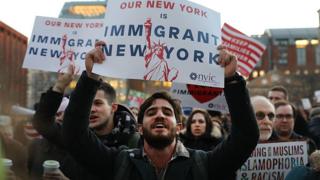 Manifestantes exibem cartazes pro-imigrantes em Nova York