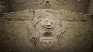 Una foto de la zona arqueológica de Caral que muestra la figura de una rana antropomórfica descubierta en una de las edificaciones de la civilización Caral, al norte de Lima.