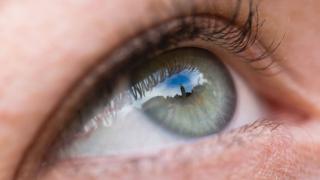A city skyline reflected in a woman's eye