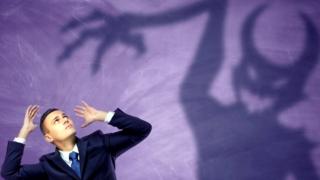 La sombra de un demonio y un hombre vestido de ejecutivo