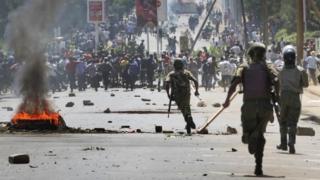 Riot police chase protesters calling for the disbandment of the national electoral commission over allegations of bias and corruption, in Kisumu, Kenya Monday, June 6, 2016