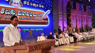 తెలుగు మహాసభల్లో ప్రసంగిస్తున్న సీఎం కె.చంద్రశేఖరరావు, వేదికపై ఉపరాష్ట్రపతి, గవర్నర్ తదితరులు