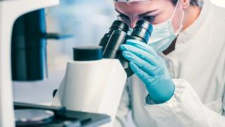 Woman looking into microscope