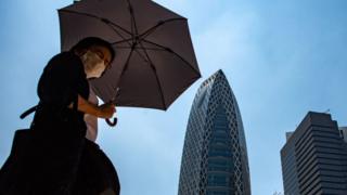 Women walks with an umbrella to shade from sun in Japan
