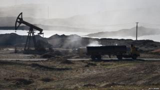 A truck sits near an oil pump in Syria
