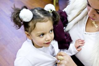 young child in white outfit