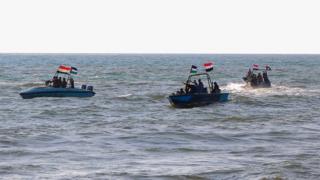 Members of the Yemeni Coast Guard affiliated with the Houthi group patrol the sea as demonstrators march through the Red Sea port city of Hodeida in solidarity with the people of Gaza on January 4, 2024, amid the ongoing battles between Israel and the militant Hamas group in Gaza.
