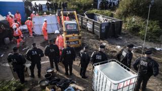 Calais mülteci kampında işçiler çadırları söküyor.
