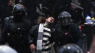 Kosovar policemen detain a man at the Vetevendosje headquarters