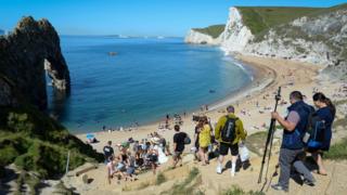 People enjoy fine weather at Durdle Door beach in Dorset