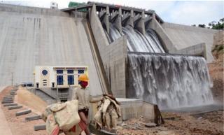 A worker in front of a large hydropower dam in Kampot province