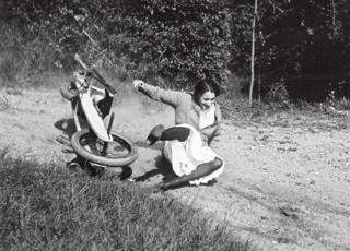A woman falls off a go-kart whilst laughing