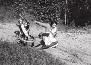 Eine Frau fällt lachend von einem Go-Kart