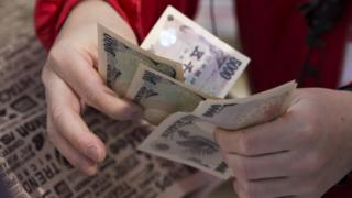 An employee counts Japanese yen notes