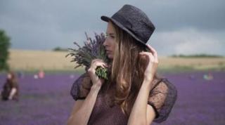 Devojka pozira za fotografiju na polju lavande