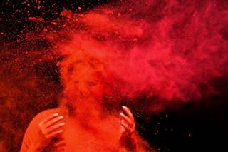 A reveller is covered with coloured powder