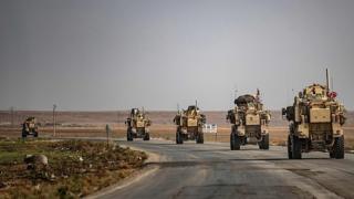 US military vehicles drive on a street in the town of Tal Tamr on October 20, 2019, after pulling out of their base