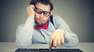 Homem em frente a teclado de computador