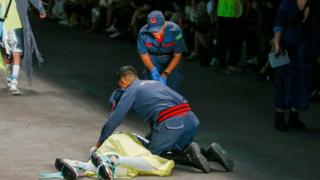 Paramedics attend to Tales Soares, who collapsed on the catwalk at Sao Paulo Fashion Week. He was later confirmed to have died