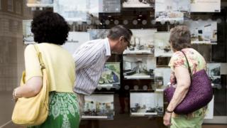 People outside estate agent's window