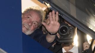 Forrmer Brazilian president Luis Inácio Lula da Silva waves to supporters from a window