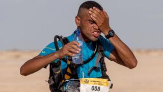 Mohamed el-Morabity kutoka Morocco, anajimwagilia maji usoni alipokuwa anakimbia na kushinda mbio za marathon za El Djerid katika nyikakatika mji wa Tozeur.