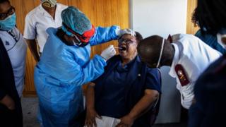 A doctor tests people for coronavirus in Johannesburg