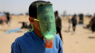 طفل صنع قناع على وجهه من زجاجة بلاستيكية