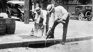 Agents pouring confiscated alcohol down the sewer, circa 1921