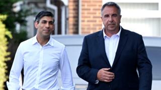 Prime Minister Rishi Sunak (left) and newly elected Conservative MP Steve Tuckwell arriving at the Rumbling Tum cafe in Uxbridge