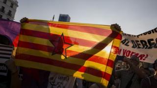 Manifestantes concentrados en la Puerta del Sol de Madrid con banderas de Cataluña para protestar contra las detenciones del pasado día 20.