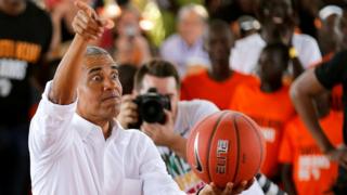 Barack Obama holds a basketball as he addresses people at the launch of Sauti Kuu resource centre in Kenya - Monday 16 July 2018
