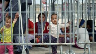 Refugees wait for registration process prior to the asylum procedure at the Helliniko refugee camp in Athens on 13 June