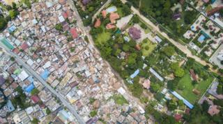 Foto aérea de grandes residencias coloniales en Oyster Bay, Sudáfrica y un asentamiento pobre vecino