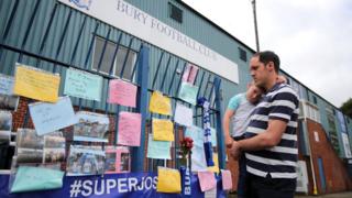 A fan reads messages at Gigg Lane