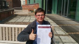 Daniel Lawson holding his exam certificates