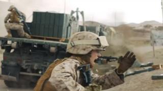 Снимок из рекламного объявления о наборе сотрудников морской пехоты, на котором изображена морская женщина под огнем